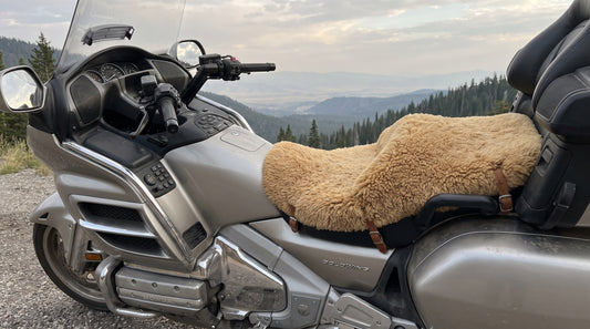 Honda Gold Wing touring bike with a sheepskin motorcycle seat pad on the saddle at a mountain overlook